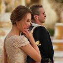 Charlotte et Alexandre, un couple de jeunes mariés souriants devant un magnifique gâteau de mariage.