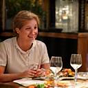 Isabelle et Marc, un couple souriant profitant d'un dîner à la maison.